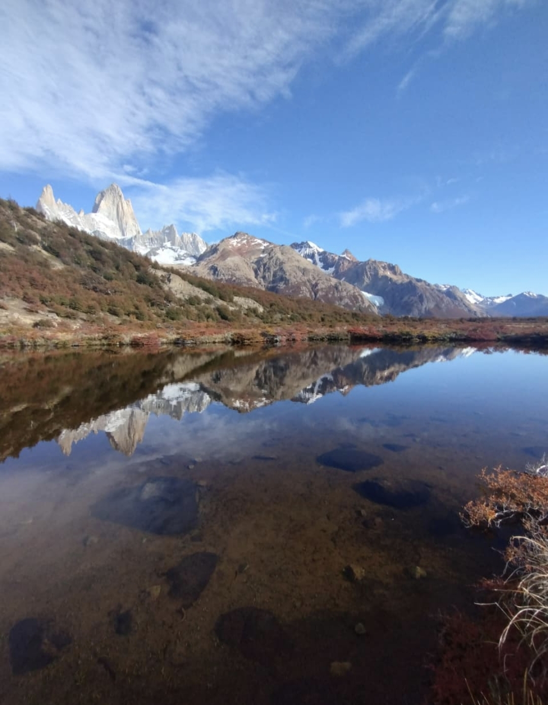 Laguna serena con el paisaje montañoso de El Chaltén reflejado